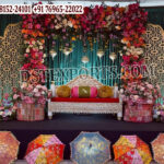 Luxury Moroccan Mehndi stage decor featuring intricate laser cut backdrop panels, colorful floral arrangements, traditional lanterns, and royal wedding sofa