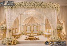 Luxury White Laser Cut Wedding Mandap For Australia Luxury White Laser Cut Wedding Mandap For Australia featuring intricate laser cut backdrop panels, colorful floral arrangements, traditional lanterns, and royal wedding sofa