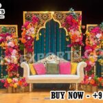Luxury Moroccan Mehndi stage decor featuring intricate laser cut backdrop panels, colorful floral arrangements, traditional lanterns, and royal wedding sofa