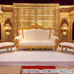 maharaja wedding stage, royal wedding backdrop gold, palace style wedding stage, carved wedding backdrop panels, luxury wedding sofa set gold, hindu wedding stage decoration, royal wedding stage setup India, antique gold wedding backdrop, designer wedding stage furniture, wedding throne sofa set, grand wedding stage decor, banquet hall wedding stage setup, wedding decor exporters India, premium wedding stage backdrop, traditional royal wedding decor, luxury event stage panels, indian wedding furniture supplier