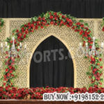 nikkah stage backdrop, walima stage decoration, laser cut wedding panels, Mughal arch wedding backdrop, gold wedding stage backdrop, floral wedding stage decor red theme, luxury wedding stage setup, Islamic wedding stage decoration, reception stage backdrop design, designer wedding panels India, chandelier wedding stage decor, elegant wedding backdrop panels, banquet hall wedding stage setup, premium wedding decor backdrop, carved jali panels wedding, floral arch wedding stage, wedding backdrop exporters India, royal wedding stage decoration, event stage panels supplier
