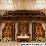 temple theme wedding stage, muhurtham stage decoration, South Indian wedding stage setup, carved wooden wedding stage, temple style mandap stage, traditional Hindu wedding stage decor, wooden carved backdrop panels, Indian wedding stage decoration, luxury wedding stage India, mandap stage manufacturers India, wedding decor exporters India, cultural wedding stage setup, banquet hall wedding stage decor, designer temple stage backdrop, premium wedding stage decoration