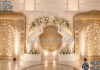 Luxury Arangetram Stage Decoration With Big Elephants Luxury Arangetram stage decoration with golden carved backdrop panels, large white elephant statues, floral arch décor, and elegant warm lighting for a traditional South Indian cultural event.