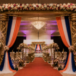 Tamil wedding mandap, golden FRP mandap, crystal wedding mandap, traditional Hindu mandap, South Indian wedding décor, luxury wedding mandap, carved FRP pillars, Tamil marriage mandap, Sankheda wedding seating, wedding ceremony mandap, floral mandap decoration, premium wedding stage, decorative mandap pillars, Indian wedding canopy, royal wedding mandap setup, banquet hall mandap décor, engagement ceremony mandap, handcrafted wedding mandap, cultural wedding stage, designer wedding mandap, luxury Hindu wedding setup, FRP wedding décor, traditional marriage stage, elegant mandap decoration, destination wedding mandap