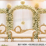 Victorian wedding stage, bride groom sofa set, luxury wedding sofa, floral wedding backdrop, royal wedding stage décor, Victorian style furniture, wedding reception stage, designer wedding sofa, floral arch backdrop, gold wedding furniture, premium wedding seating, carved wedding sofa set, luxury stage decoration, elegant wedding setup, bridal stage décor, wedding event furniture, banquet hall wedding stage, classic wedding sofa, ornate wedding chairs, reception stage sofa set, white floral wedding backdrop, luxury wedding furniture exporters, traditional wedding stage, royal bride groom chairs, premium wedding décor setup