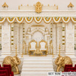 Tirupati theme wedding mandap, temple wedding mandap decor, South Indian wedding mandap, luxury wedding mandap, royal mandap decoration, carved wedding mandap, white and gold mandap, Indian wedding stage decor, traditional mandap setup, premium wedding mandap, wedding stage backdrop, elephant carved mandap, Hindu wedding mandap, designer wedding mandap, handcrafted mandap decor, wedding pavilion, ornate wedding stage, luxury mandap exporters, carved pillar mandap, wedding event decor manufacturer