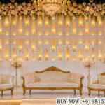 white wedding backdrop, jharokha backdrop panel, luxury wedding stage décor, illuminated wedding backdrop, floral wedding backdrop, royal wedding stage, designer wedding backdrop, luxury reception stage, white theme wedding décor, wedding stage setup, ornate backdrop panels, banquet hall wedding décor, floral stage decoration, premium wedding backdrop, elegant wedding stage, chandelier wedding décor, decorative wedding panels, destination wedding stage, cultural wedding décor, wedding couple seating, luxury stage furniture, floral wedding stage, grand wedding backdrop, handcrafted wedding décor, luxury event backdrop
