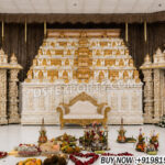 Rajagopuram wedding mandap, South Indian temple mandap, luxury wedding mandap decor, temple style wedding stage, traditional wedding mandap, grand wedding backdrop, white and gold mandap, carved wedding stage, premium wedding decor, Indian wedding stage setup, royal wedding mandap, handcrafted mandap design, South Indian wedding decor, designer wedding stage, ornate temple backdrop, luxury wedding furniture, wedding event decor manufacturer, carved pillar mandap, wedding reception stage, Hindu wedding mandap setup