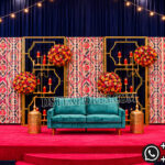 candle lit wedding stage, green gold wedding backdrop, candle wall wedding decor, luxury wedding stage backdrop, engagement stage green gold theme, wedding stage with candles, elegant wedding backdrop panels, floral frame wedding stage, modern wedding stage decor, reception stage backdrop design, candle light wedding decoration, designer wedding stage India, banquet hall wedding decor, wedding decor exporters India, premium event backdrop panels, wedding stage with green panels, contemporary wedding backdrop design