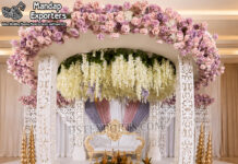 Luxury Laser Cut Design Round Wedding Mandap Luxury laser cut design round wedding mandap featuring four decorative white laser-cut pillars, a grand circular floral canopy with pink and white flowers, hanging floral arrangements, elegant wedding sofa, and traditional havan setup for Hindu wedding ceremonies.