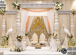 Prestige Look Indian Wedding Mandap Luxury White and Gold Indian Wedding Mandap with six carved pillars, elegant drapes, floral arrangements, decorative peacock stands, royal wedding chairs, and traditional Hindu wedding stage setup by DST Exports.