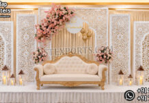Royal Reception Stage Decor Manufacturer & Supplier Royal wedding reception stage backdrop with white laser cut panels, luxury sofa and floral decorations for Australian wedding decorators.