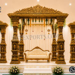 Grand Tirumala Temple-inspired golden fiber mandap with eight carved pillars, ornamental crown tops and matching side frames for South Indian weddings.