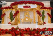 Grand Gold Carved Triveni Mandap for Hindu Weddings Grand gold carved Triveni mandap with temple-style pillars, circular canopy and red flowers for Hindu weddings.